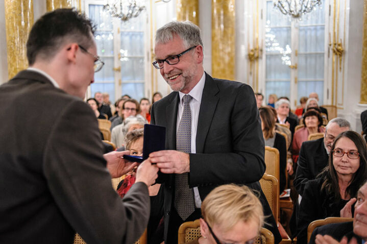 Medal Adrianowi Thomasowi wręcza Marcin Krajewski - Wręczenie medali 100-lecia urodzin kompozytora